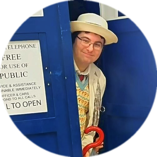 Wes in 7th Doctor cosplay, peeking out of a TARDIS